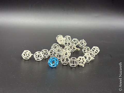 Dozens of silver dodecahedra and one resin one